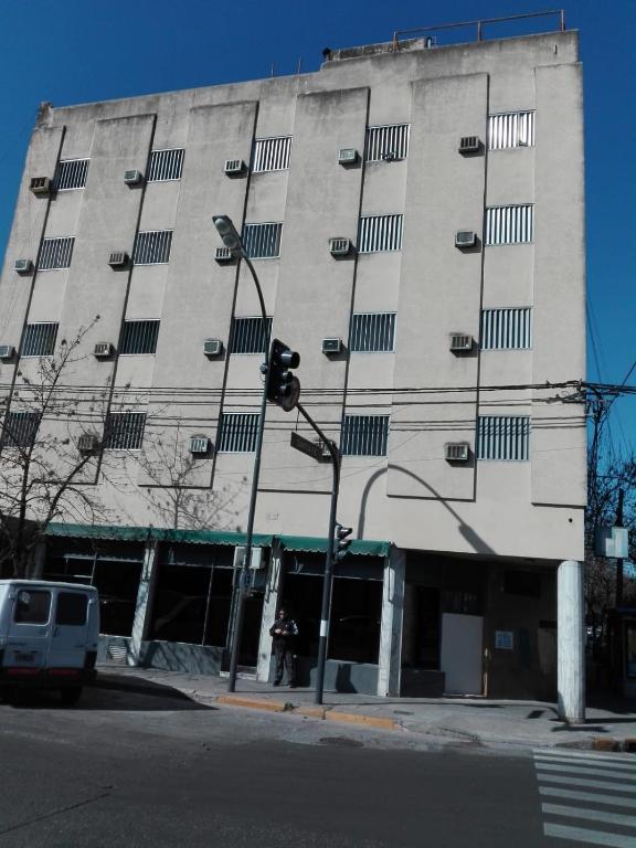 un edificio alto con un semáforo delante de él en Alojamiento Avellaneda en Rosario