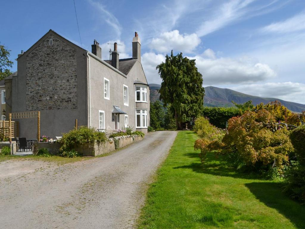 una vieja casa de piedra en un camino de tierra en Jenkin Lodge, en Braithwaite