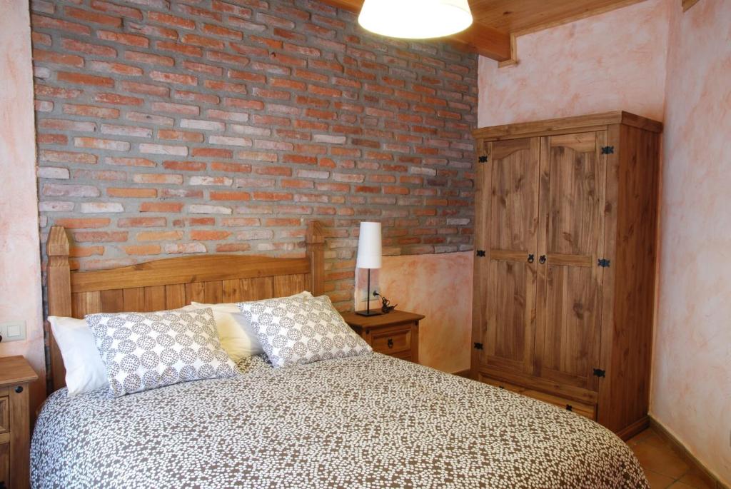 una camera con letto e muro di mattoni di la barrera a Soto y Amío