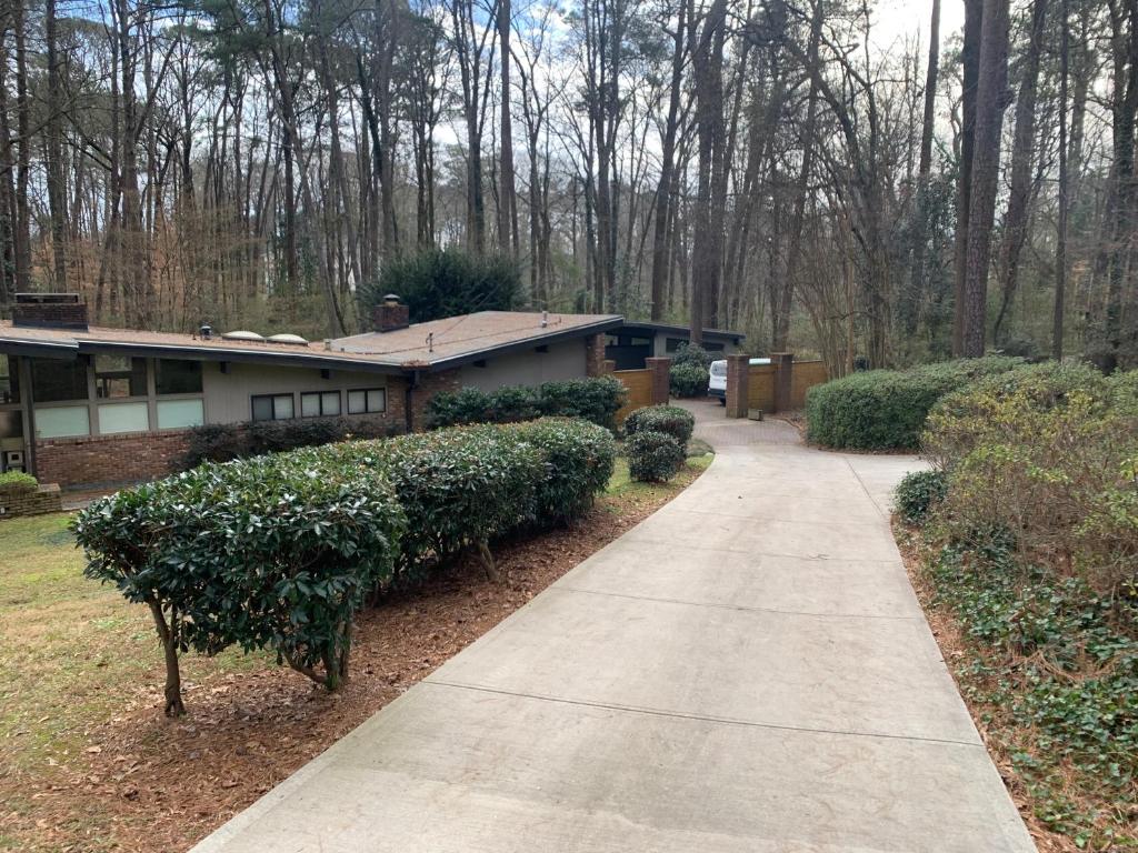 a house with a sidewalk in front of it at [RARE] Buckhead Mid-century Masterpiece! in Atlanta