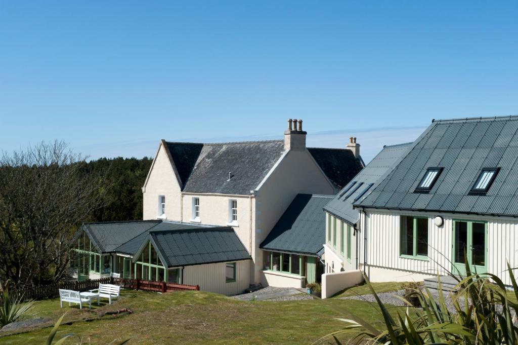 a group of white houses with black roofs at Langass Lodge in Carinish