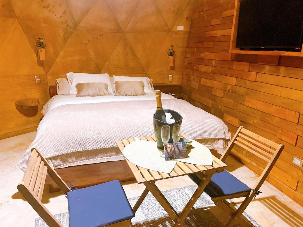 a bedroom with a bed and a table with a bottle of wine at DOMO Y SPA INFINITO in Catillo