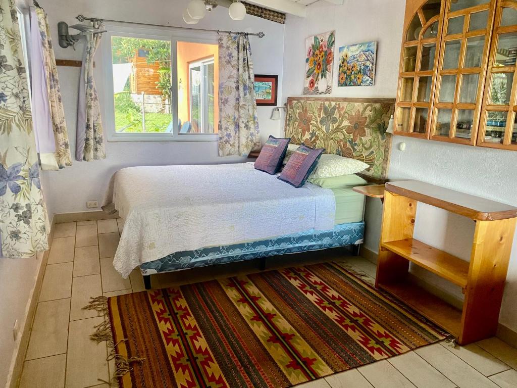 een kleine slaapkamer met een bed en een raam bij Lake Front Retreat in Santa Cruz La Laguna