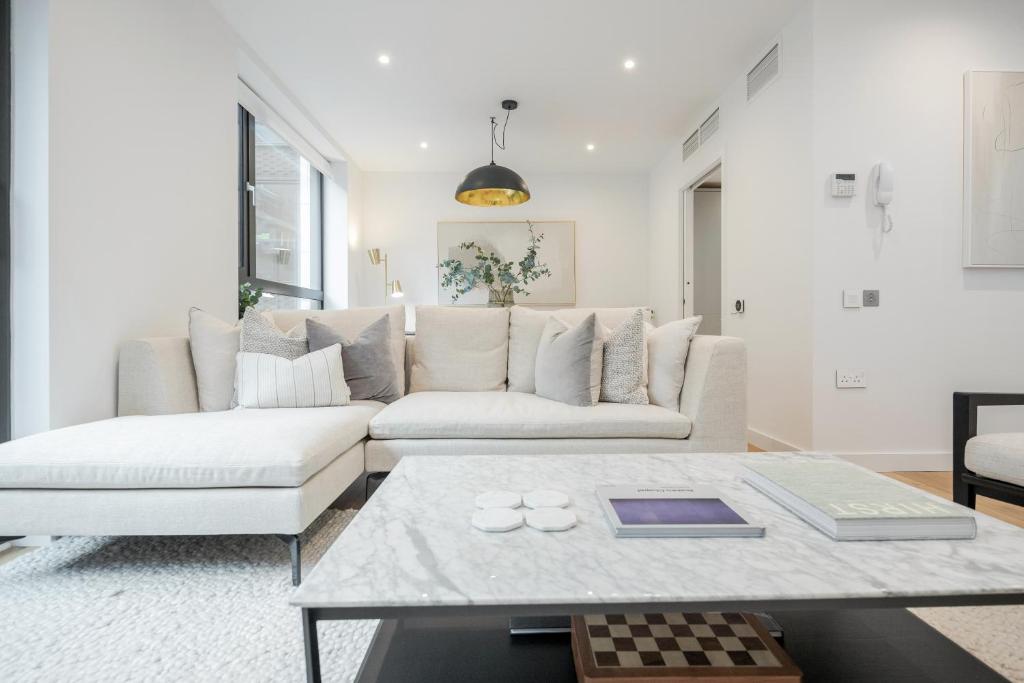 uma sala de estar com um sofá branco e uma mesa em Luxury Central Mayfair Townhouse with A/C 3BR 3BA em Londres