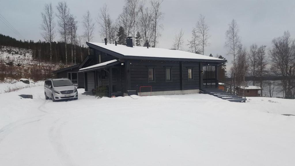Holiday home Korpraali by Päijänne-lake في Vaajakoski: شاحنة متوقفة أمام كابينة في الثلج
