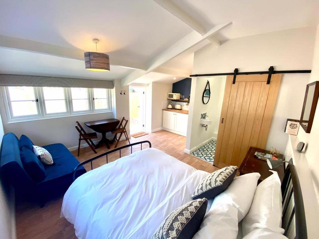 Long BurtonにあるThe Snug at Caphays: perfect rural retreatのベッドルーム1室(ベッド1台、ソファ、テーブル付)