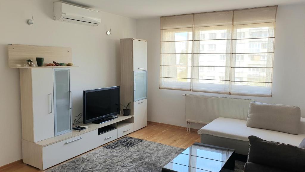 a living room with a couch and a television at ELEGANCE Apartment in Sarajevo