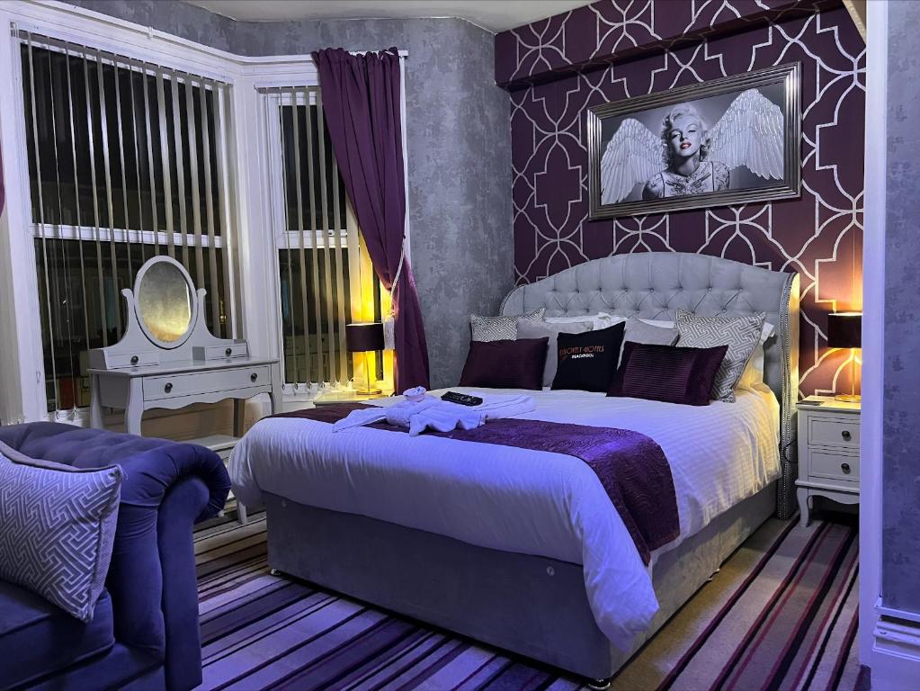 ブラックプールにあるDelovely Hotelの紫の壁のベッドルーム1室(大型ベッド1台付)