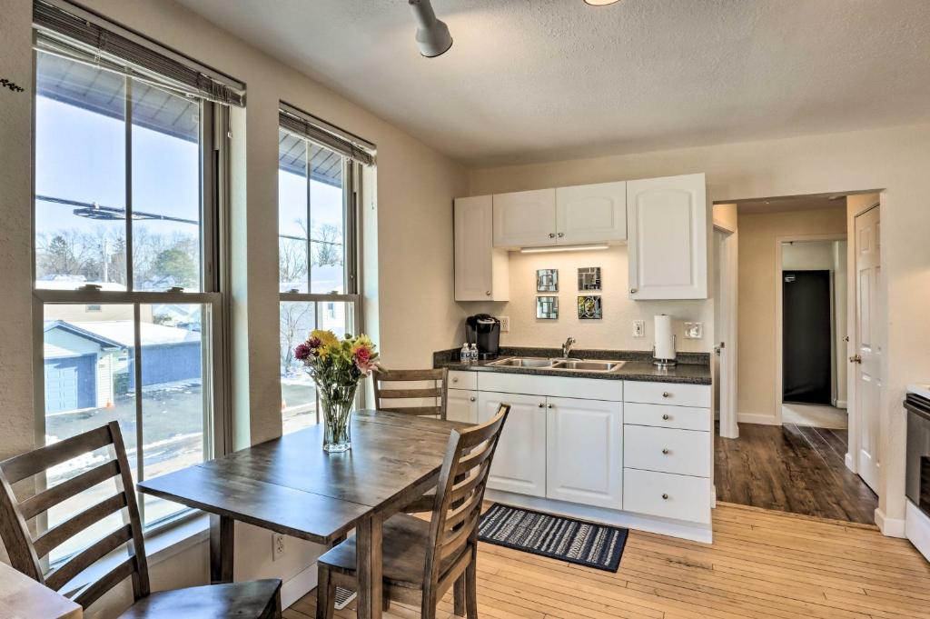 una cocina con mesa y sillas y una cocina con armarios blancos. en Delafield Vacation Rental Near Lakes and Parks!, en Delafield