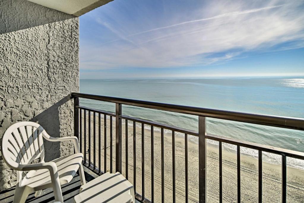a white chair sitting on a balcony overlooking the ocean at Oceanfront Myrtle Beach Condo with Balcony! in Myrtle Beach