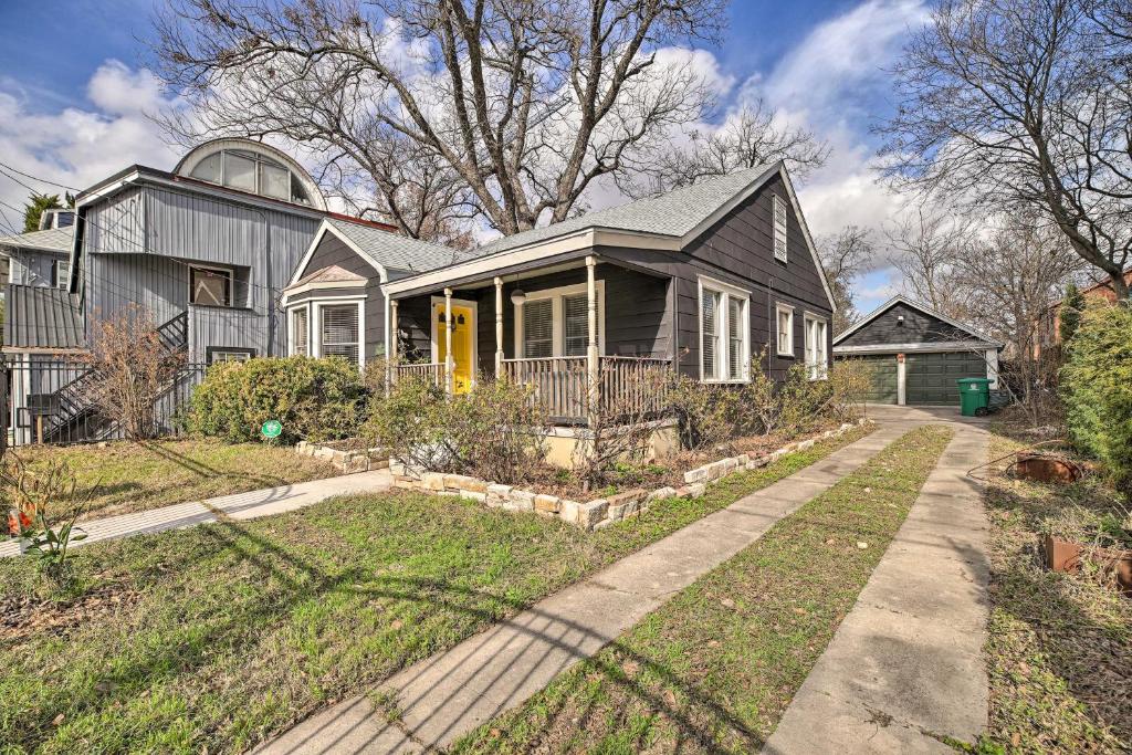 a gray house with a yellow door and a driveway at Charming Historic Houston Home with Yard! in Houston