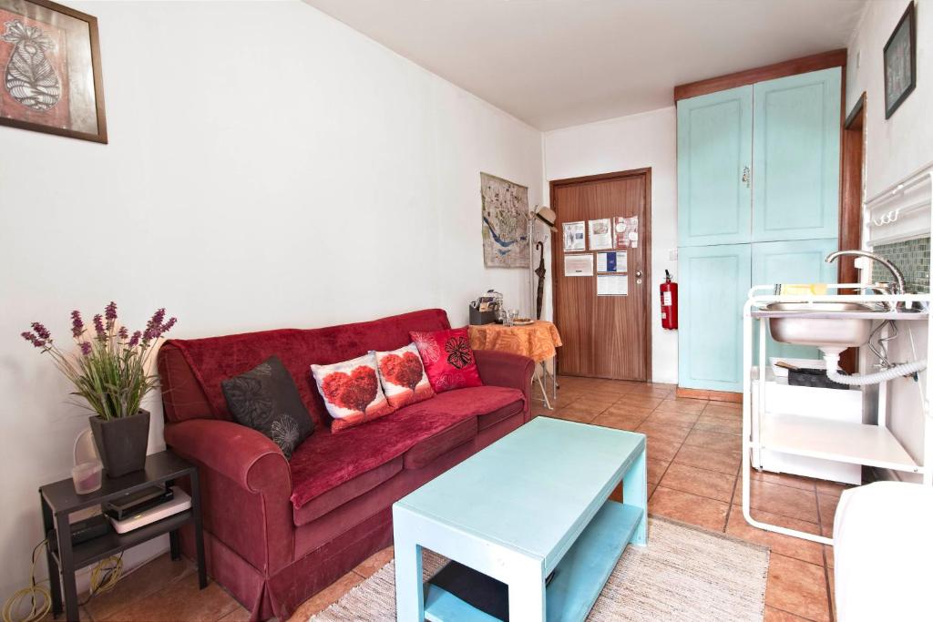 a living room with a red couch and a table at Ribeira Smart Suite in Porto