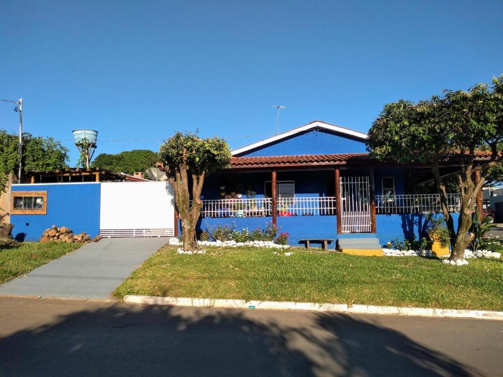 uma casa com uma parede azul e árvores em frente em Casa da Joci em Bonito