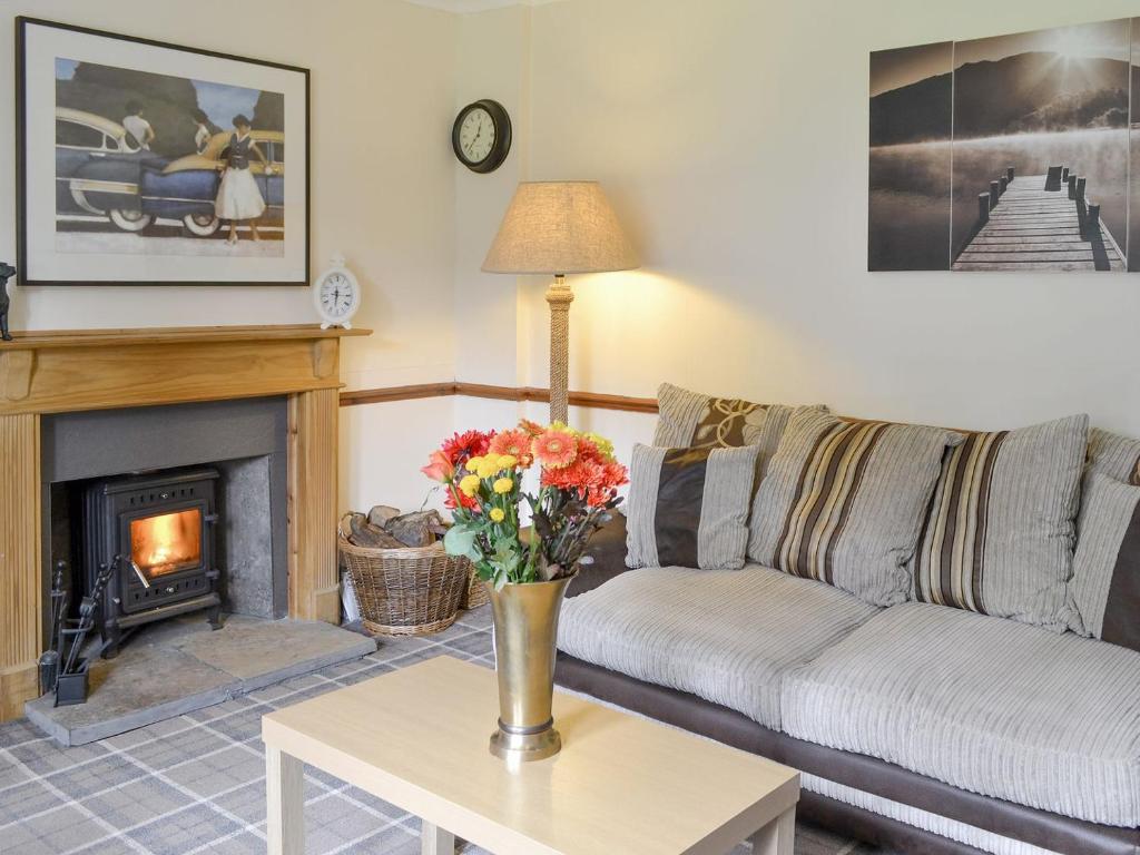 a living room with a couch and a fireplace at Nursery Cottage - Beaufort Estate in Kiltarlty