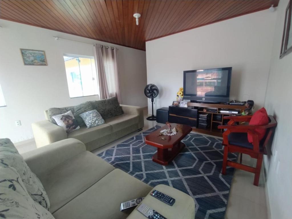 sala de estar con sofá y TV en Casa de férias, en Bombinhas