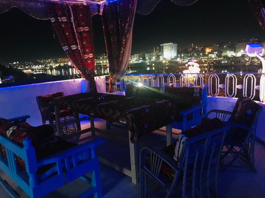 a table and chairs on a balcony at night at Gamal Robob Nubian Guest House in Aswan