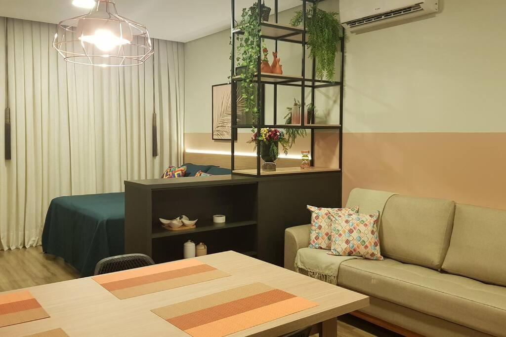- un salon avec un canapé et une table dans l'établissement Studio com piscina Ingleses Florianópolis 202, à Florianópolis