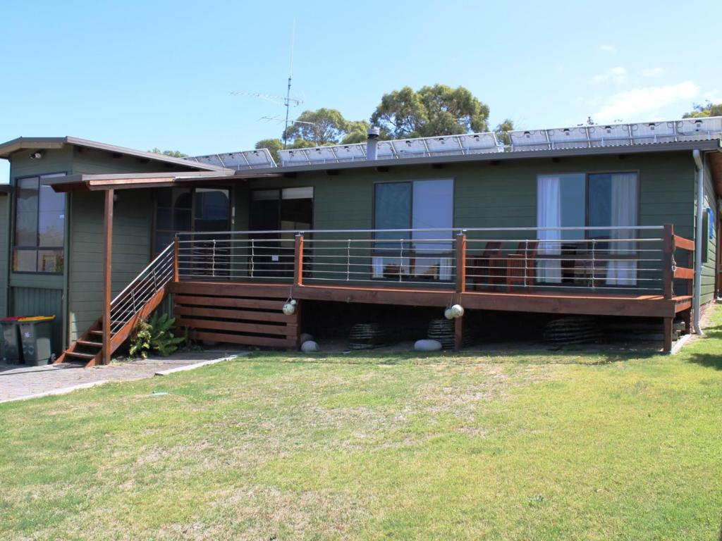 una casa con una gran terraza en un patio en Hazards House en Coles Bay