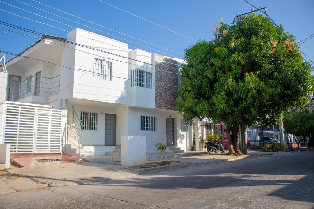 un edificio bianco con un albero di fronte di APARTAMENTO VALLEDUPAR a Valledupar