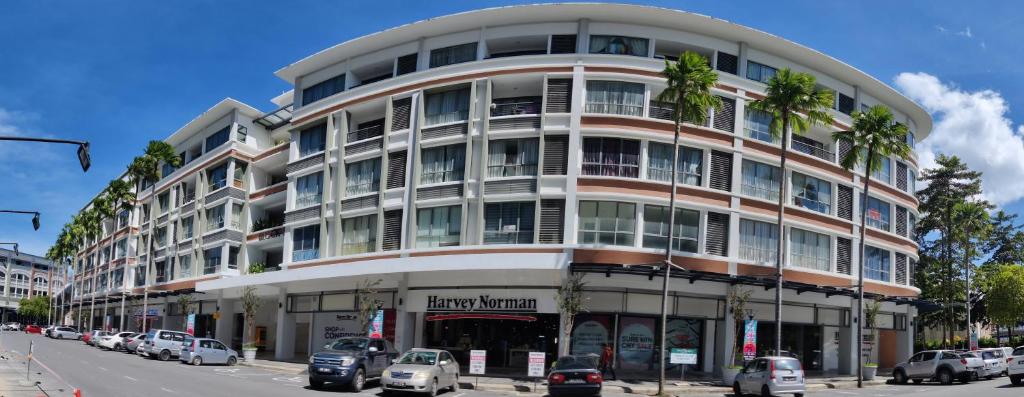 un edificio alto con coches estacionados frente a él en My Daily Homestay - Miri Times Square en Miri