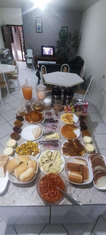 una mesa con muchos tipos diferentes de comida en ella en HOTEL Rafael en Bom Retiro