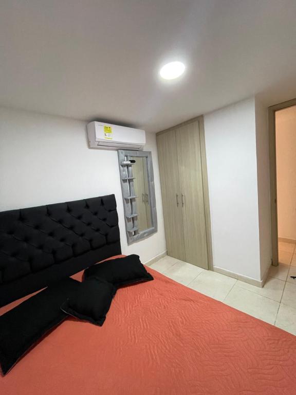 Habitación con sofá y alfombra roja. en Habitación doble en Barranquilla
