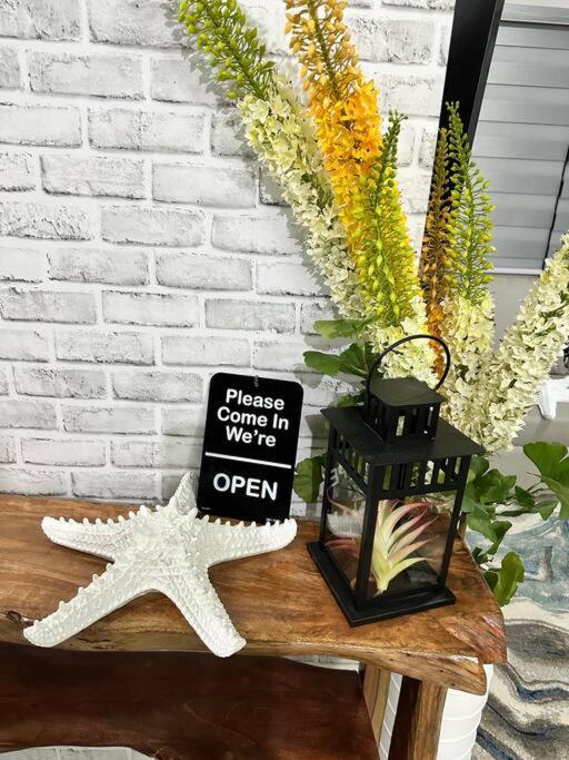 a sign sitting on a table next to a starfish at Seafront OnCall - private jacuzzi with 4 cozy bedrooms in San Juan