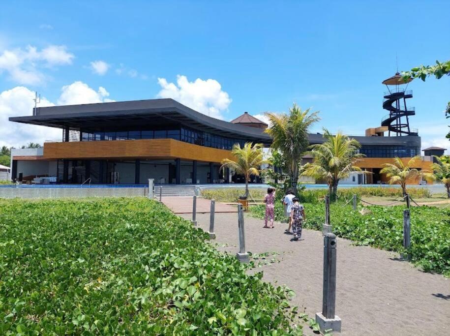 two children walking in front of a building with palm trees at Seafront OnCall - private jacuzzi with 4 cozy bedrooms in San Juan