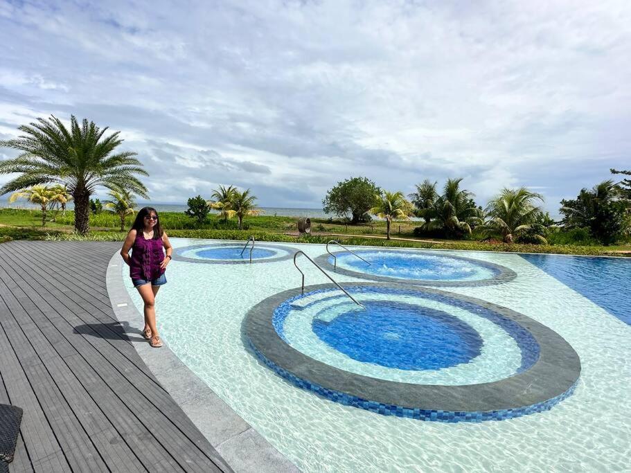 a woman walking next to a swimming pool at Seafront OnCall - private jacuzzi with 4 cozy bedrooms in San Juan