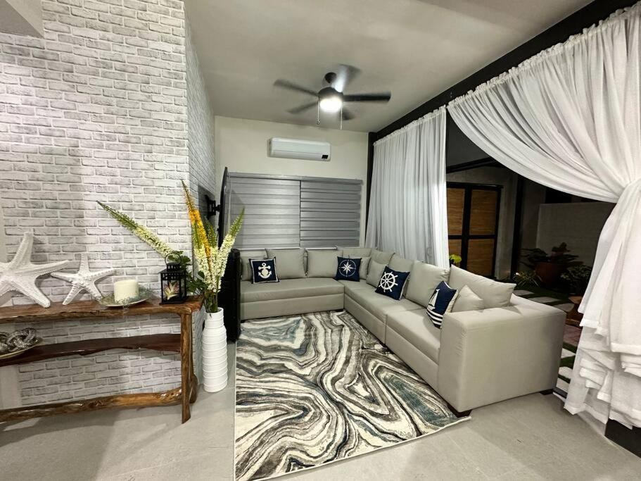 a living room with a couch and a brick wall at Seafront OnCall - private jacuzzi with 4 cozy bedrooms in San Juan