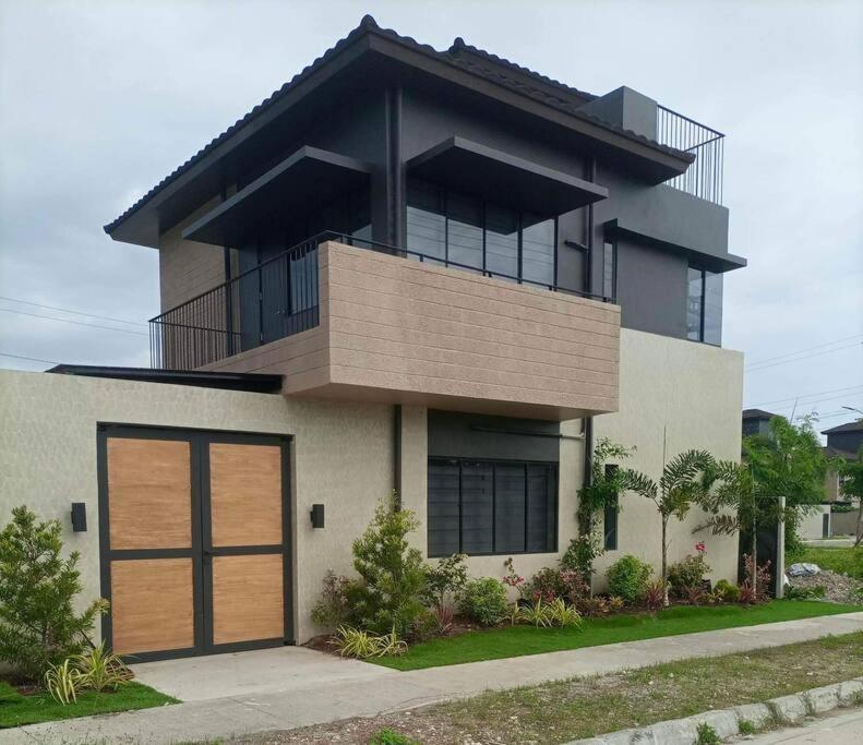 a large house with a wooden garage door at Seafront OnCall - private jacuzzi with 4 cozy bedrooms in San Juan