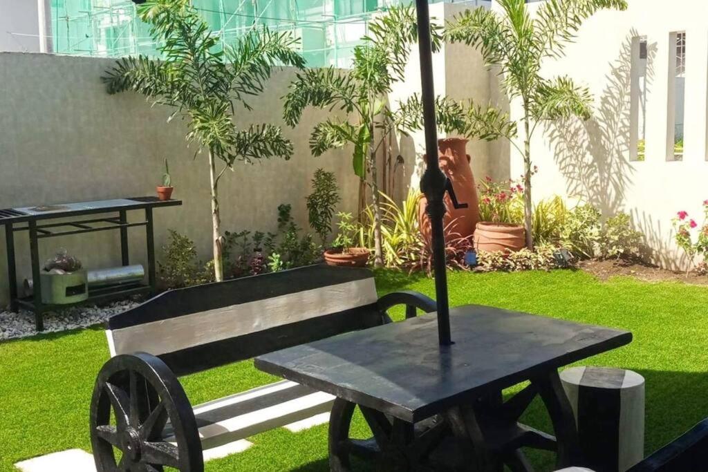a bench with an umbrella next to a table at Seafront OnCall - private jacuzzi with 4 cozy bedrooms in San Juan