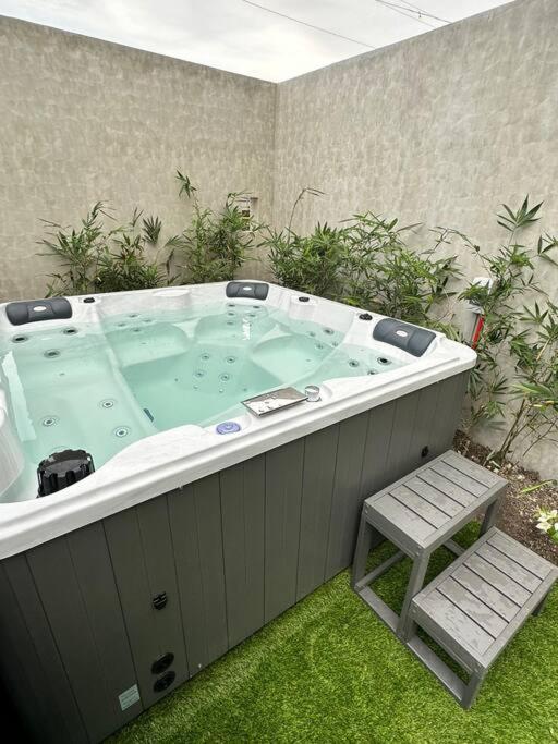 a large hot tub in a yard with a stool at Seafront OnCall - private jacuzzi with 4 cozy bedrooms in San Juan