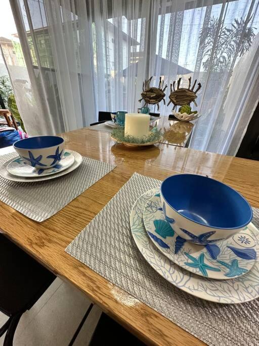 a wooden table with two blue and white cups and plates at Seafront OnCall - private jacuzzi with 4 cozy bedrooms in San Juan