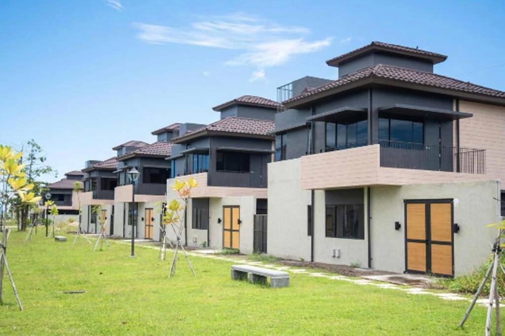 a row of houses with a green field in front at Seafront OnCall - private jacuzzi with 4 cozy bedrooms in San Juan