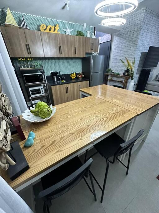 a kitchen with a wooden counter top with a table at Seafront OnCall - private jacuzzi with 4 cozy bedrooms in San Juan