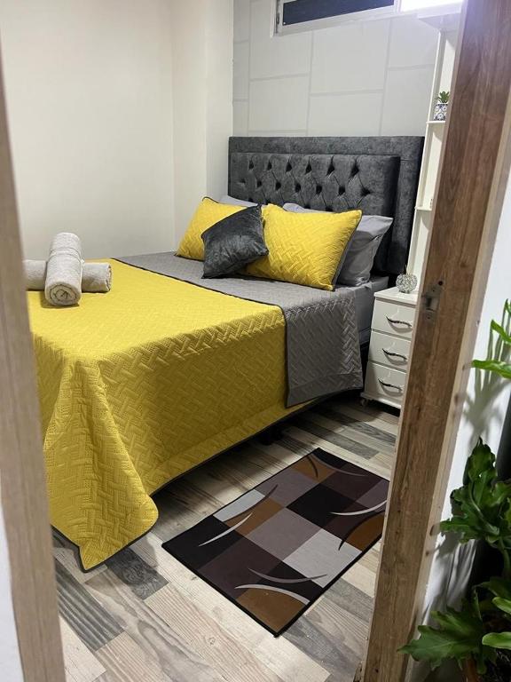 sypialnia z łóżkiem z żółtą narzutą w obiekcie Lindo Apartaestudio cerca al centro w mieście Itagüí