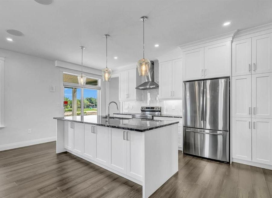 a kitchen with white cabinets and a stainless steel refrigerator at Queen bedroom in Windsor