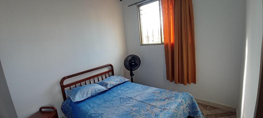 a bedroom with a bed and a window and a fan at Hermoso apartamento duplex en el centro histórico de San Gil, 5 in San Gil