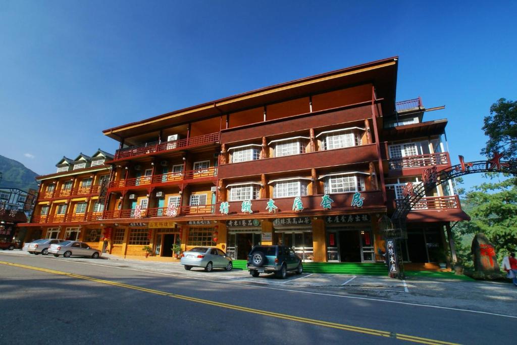 a red building with cars parked in front of it at Kingtaiwan Hotel in Lugu Lake