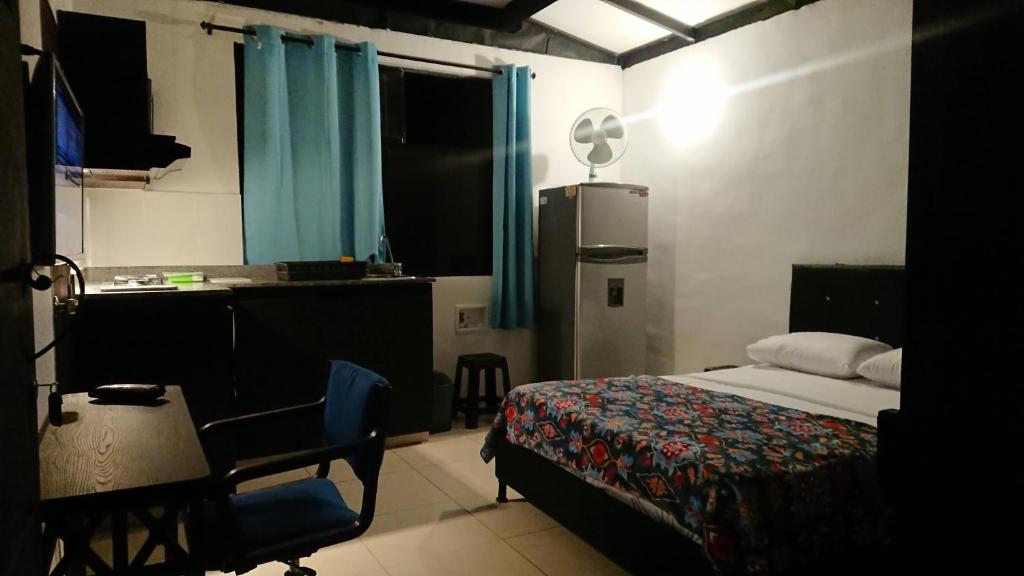 1 dormitorio con cama, escritorio y mesa en Apartasuites Medellin Laureles Nogal, en Medellín