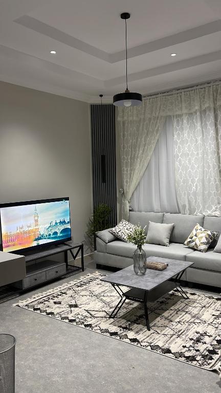 a living room with a couch and a flat screen tv at دخول ذاتي - غرفة نوم وصالة جلوس (هادئة وخصوصية عالية) in As Sayl aş Şaghīr