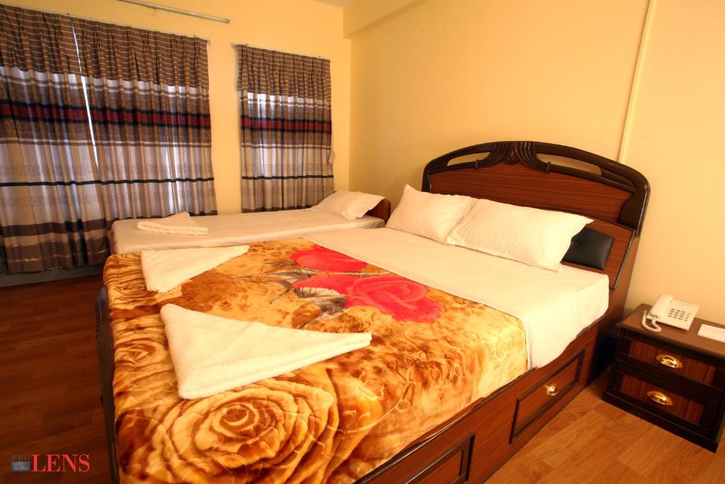 een slaapkamer met 2 bedden met een bloem erop bij Hotel Melungtse & Apartment in Tokna