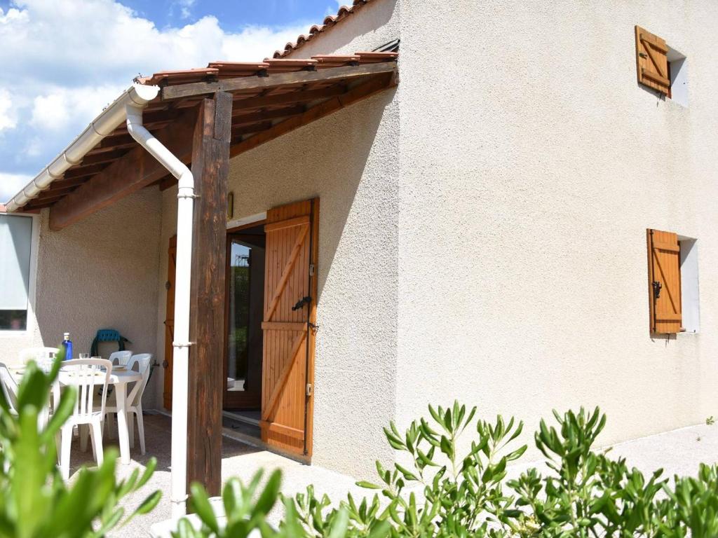 une porte en bois d'une maison avec une table et des chaises dans l'établissement Maison Gruissan, 2 pièces, 6 personnes - FR-1-229-839, à Gruissan