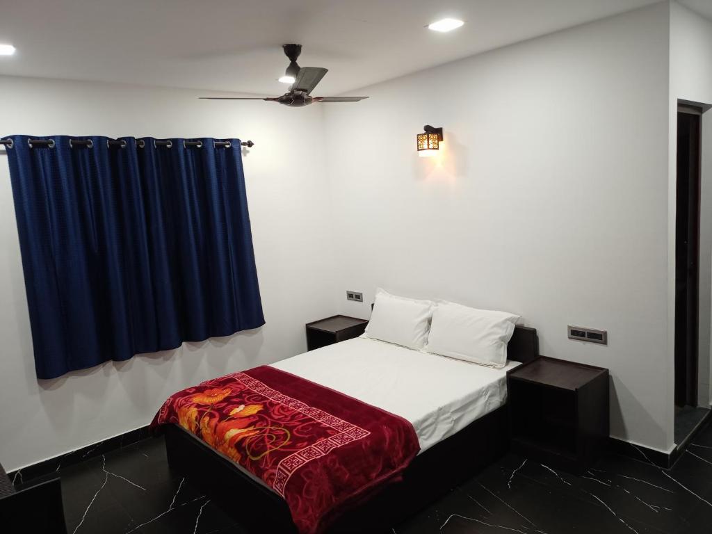 um quarto com uma cama com uma cortina azul em La casa de Alexa homestay em Idukki