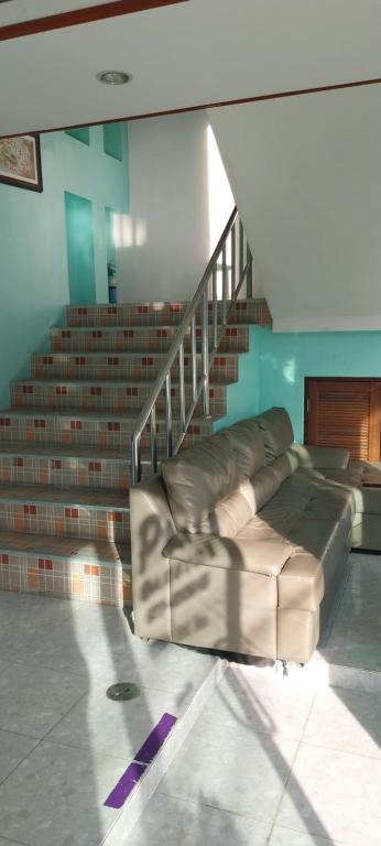 a leather couch sitting in front of a staircase at Ava 2 Budget Hotel Koh Tao in Koh Tao