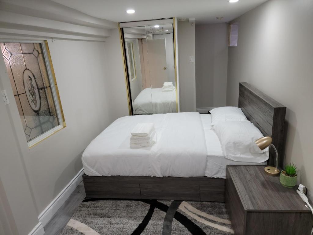 1 dormitorio con 1 cama grande y espejo en Comfy Private Unit, en Toronto