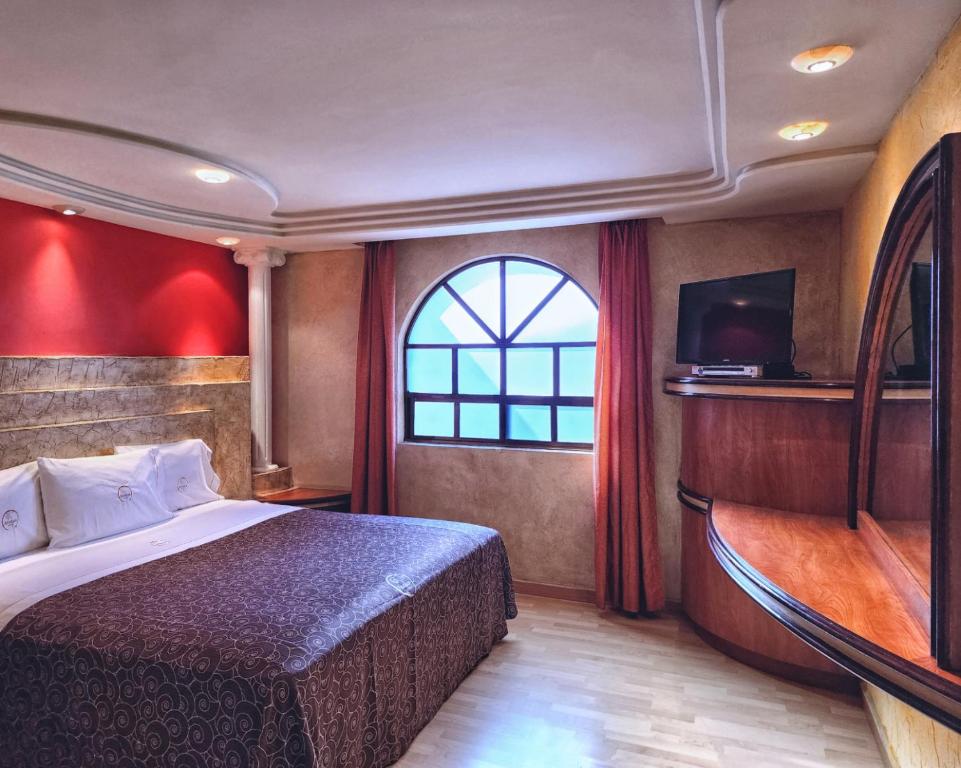a hotel room with a bed and a window at Motel Atenas in Puebla