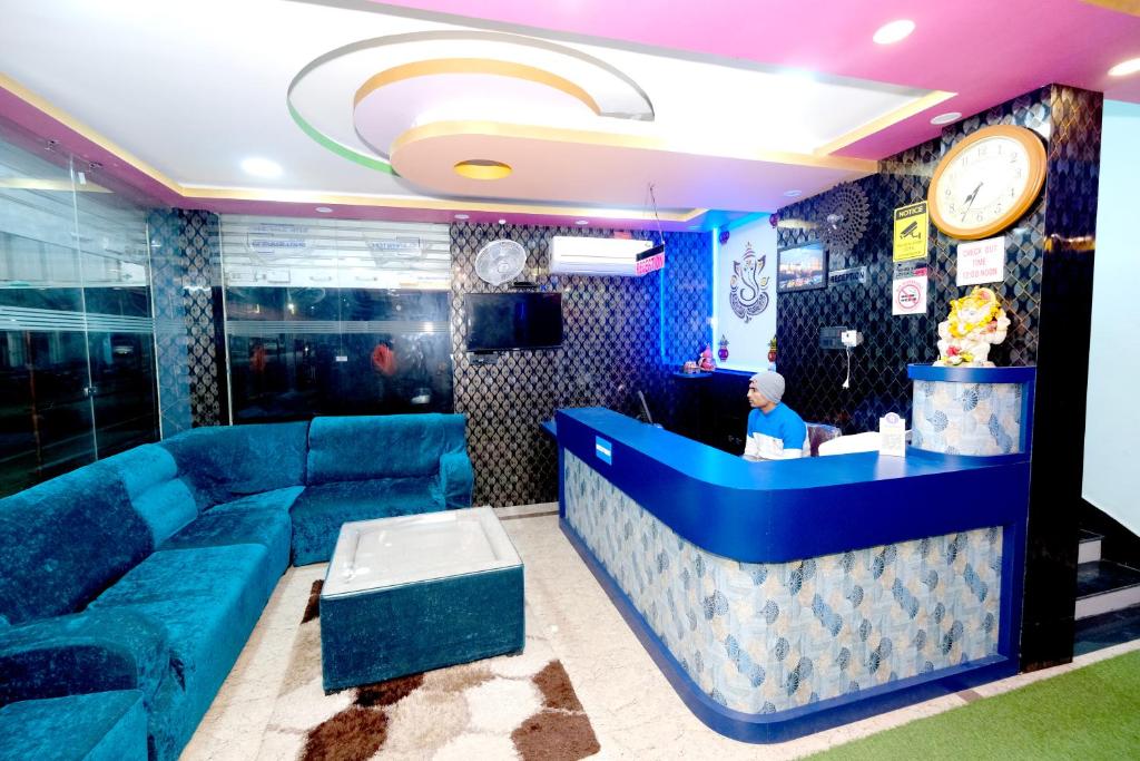 a lobby with a blue couch and a bar at Hotel Krishna Paradise in Deoghar