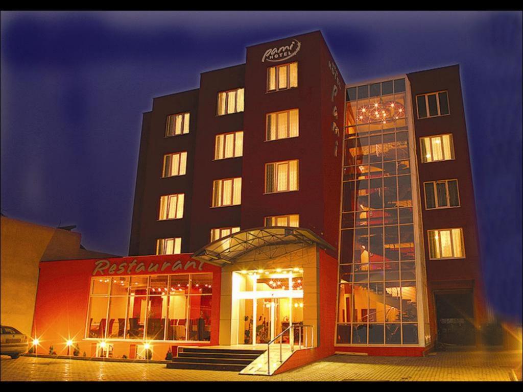 um hotel com um edifício com luzes em frente em Hotel Pami em Cluj-Napoca